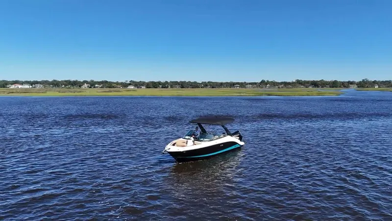 Slide: The Image of A 2027 Sea Ray SLX 260 Outboard on calm waters under a clear blue sky. - 14