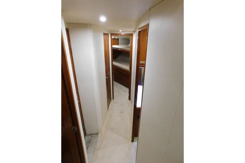 Slide: The Image of Interior hallway of 1996 Viking 50 Convertible yacht with wooden doors and carpeted floor. - 43