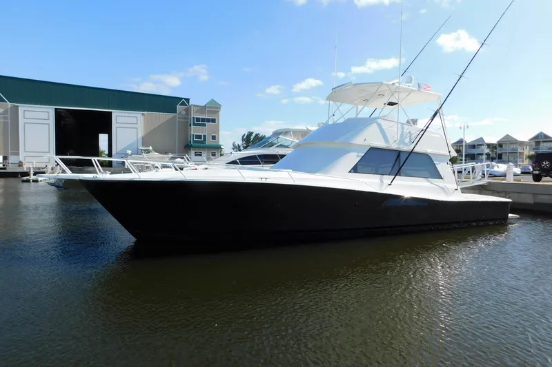 Slide: The Image of 1996 Viking 50 Convertible yacht docked at marina under clear blue sky. - 1