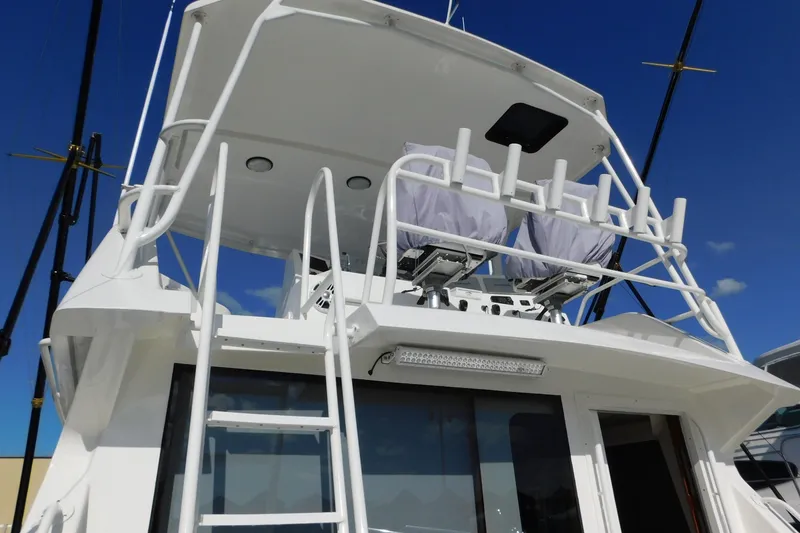 Slide: The Image of 1996 Viking 50 Convertible yacht with upper deck and ladder under clear blue sky. - 7