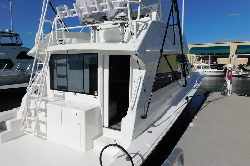 Slide: The Image of 1996 Viking 50 Convertible yacht docked at marina, featuring sleek design and spacious deck. - 6