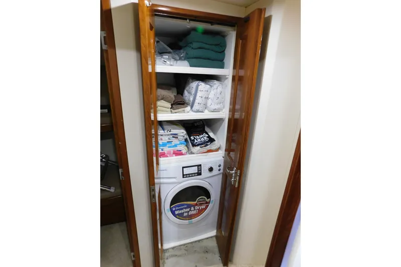 Slide: The Image of Laundry area with washer, dryer, and shelves in a 1996 Viking 50 Convertible boat. - 48
