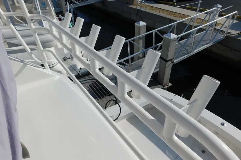 Slide: The Image of 1996 Viking 50 Convertible yacht deck with rod holders and dock view. - 8