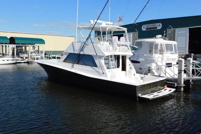 Slide: The Image of 1996 Viking 50 Convertible yacht docked at marina, clear sky, calm water. - 3