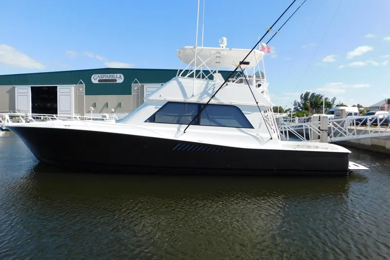 Slide: The Image of 1996 Viking 50 Convertible yacht docked at marina with clear sky background. - 2