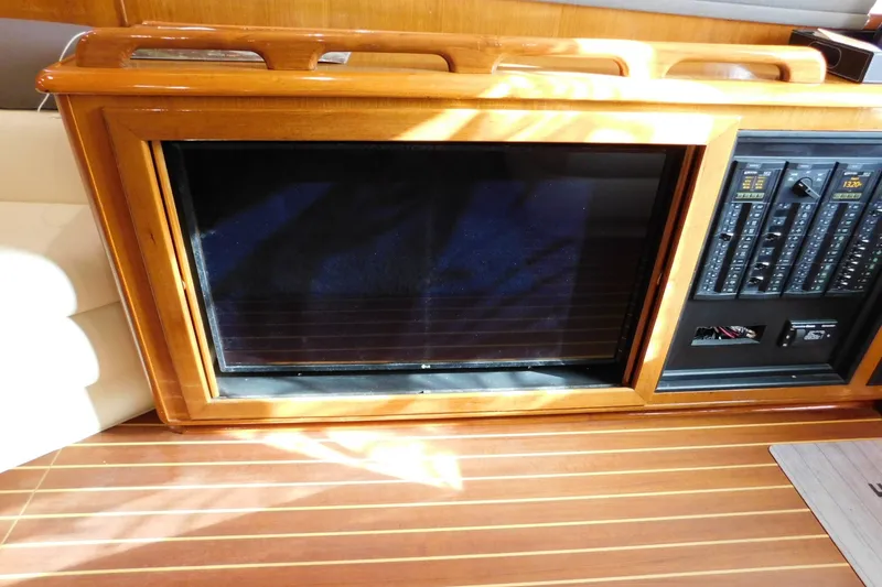 Slide: The Image of 1996 Viking 50 Convertible yacht interior with wooden paneling and control panel. - 32
