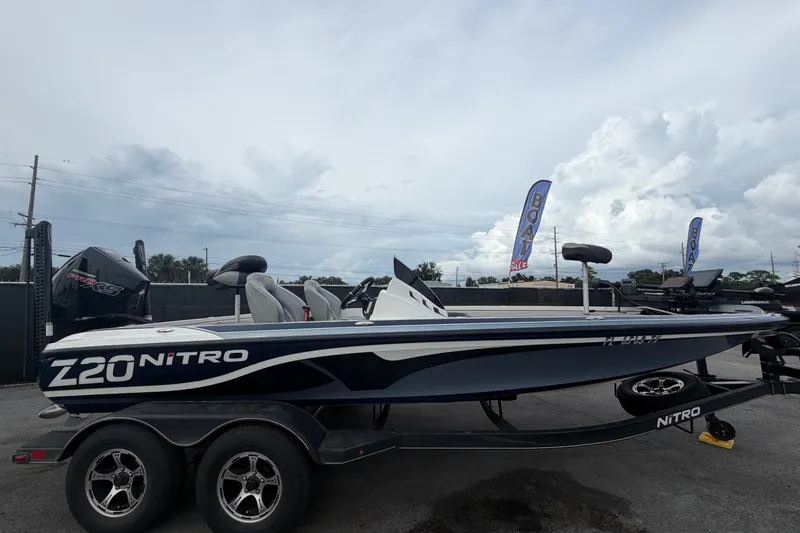 The Image of 2024 Nitro Z20 boat on trailer under cloudy sky, side view. - 0