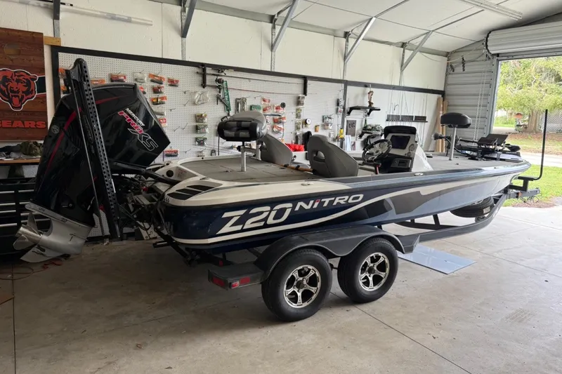The Image of 2024 Nitro Z20 in a garage, featuring two seats and a powerful outboard motor. - 5