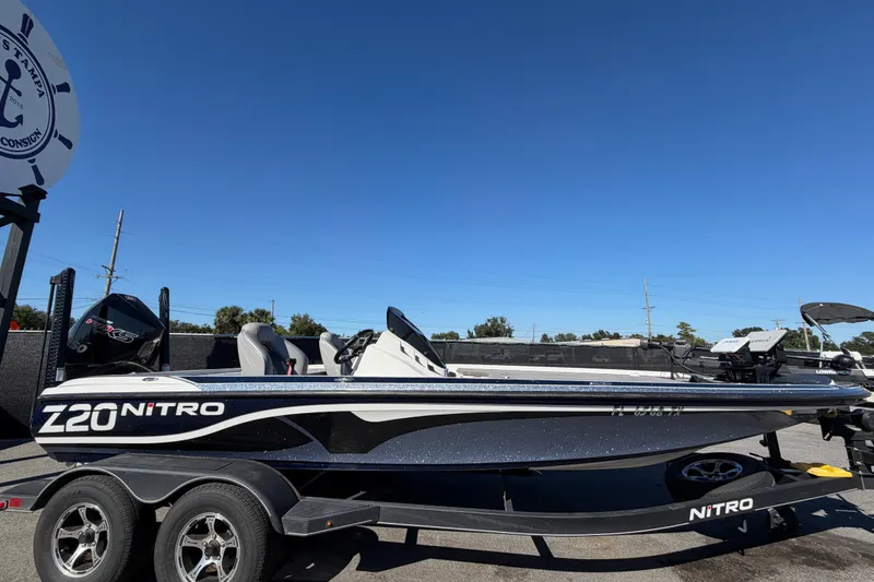 Slide: The Image of 2024 Nitro Z20 boat on trailer under clear blue sky. - 2