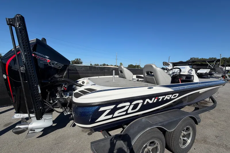 Slide: The Image of 2024 Nitro Z20 boat with Mercury Pro XS engine, parked on a trailer under clear blue sky. - 3