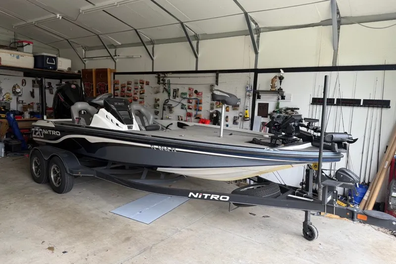 Slide: The Image of 2024 Nitro Z20 boat in garage, featuring sleek design and dual-axle trailer. - 6