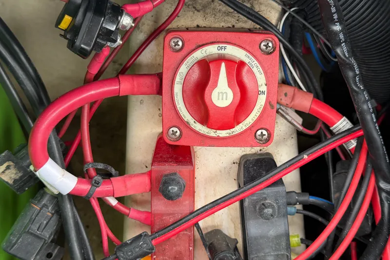 Slide: The Image of Close-up of a 2024 Nitro Z20 battery switch with red cables and connectors. - 77