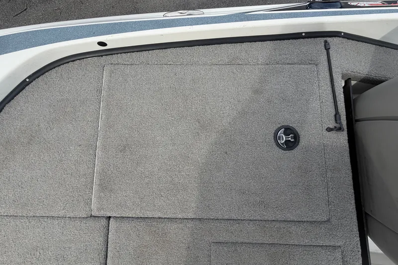 Slide: The Image of 2024 Nitro Z20 boat deck with gray carpet and storage compartment. - 70