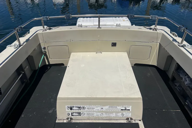 Slide: The Image of 1991 Skipjack Fisherman boat deck with storage compartments and railing, docked on calm water. - 15