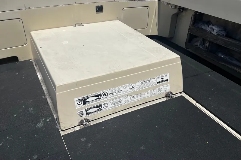 Slide: The Image of 1991 Skipjack Fisherman boat deck with storage compartment and safety labels. - 14