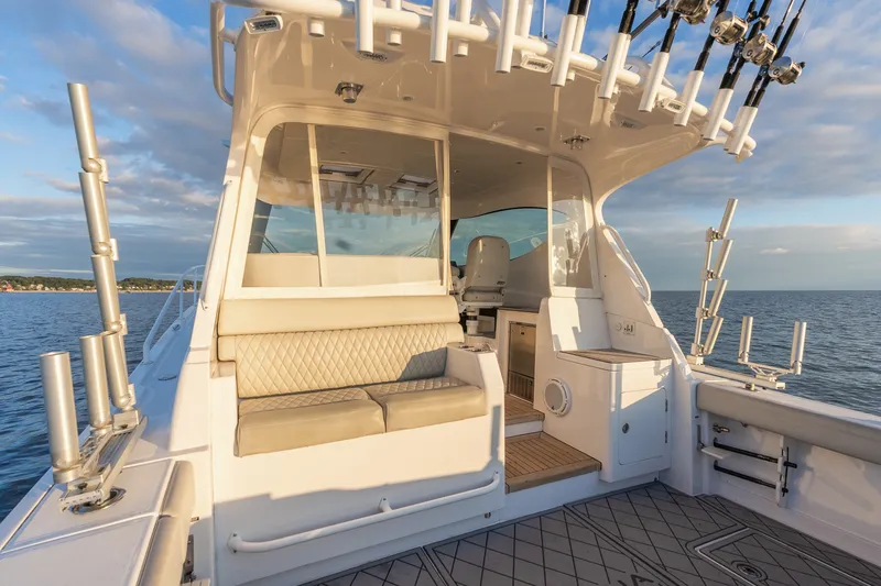 Slide: The Image of 2021 Jupiter 41 SB yacht interior with fishing rod holders, beige seating, and ocean view. - 21