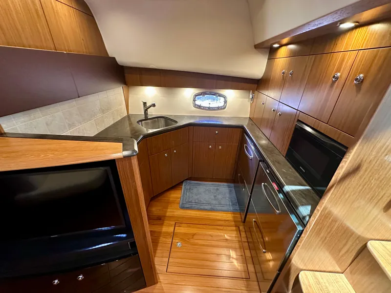 Slide: The Image of 2018 Tiara Yachts 4300 Open kitchen with wood cabinetry and modern appliances. - 24