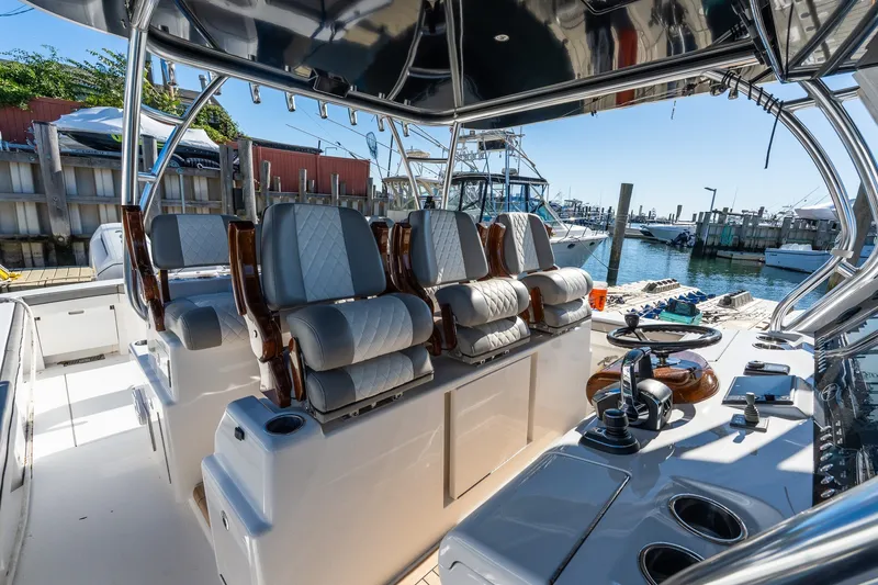 Slide: The Image of 2022 Valhalla V-46 boat interior with luxurious seating and modern controls at a marina. - 25