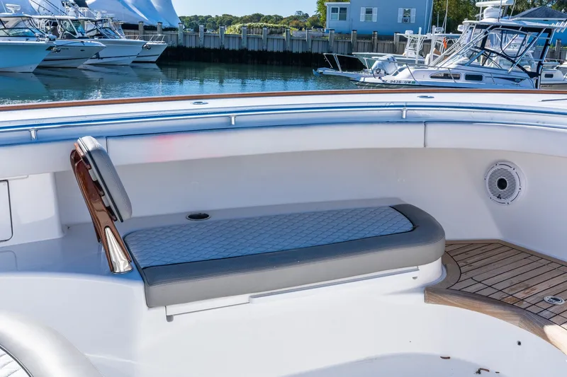 Slide: The Image of 2022 Valhalla V-46 boat interior with cushioned seating and wooden deck details. - 58