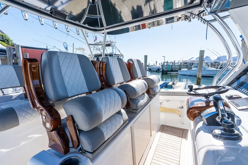Slide: The Image of Luxurious 2022 Valhalla V-46 boat interior with plush seating and modern controls at a marina. - 26