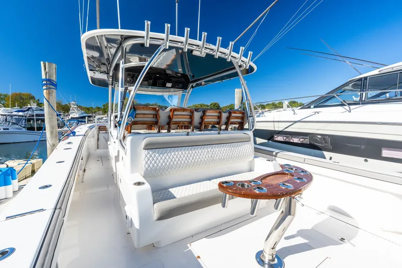 Slide: The Image of 2022 Valhalla V-46 boat interior with seating and fishing rod holders, docked at marina. - 11