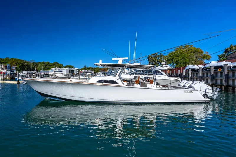 The Image of 2022 Valhalla V-46 boat docked in a marina under clear blue skies. - 0