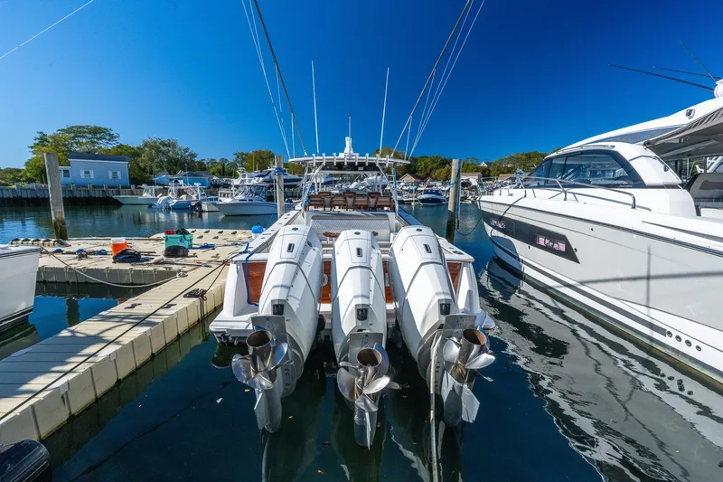 Slide: The Image of 2022 Valhalla V-46 boat docked with triple outboard engines in a marina. - 2