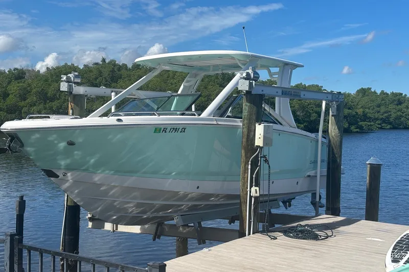 The Image of Chaparral 280 OSX 2021 boat on lift by a scenic waterfront dock. - 0