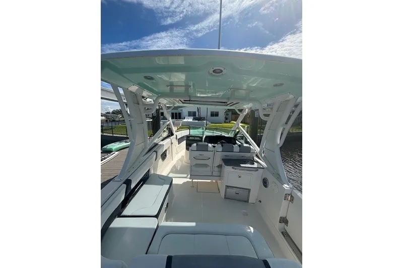 Slide: The Image of 2021 Chaparral 280 OSX boat interior with seating and helm under a clear sky. - 42