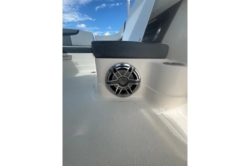 Slide: The Image of 2021 Chaparral 280 OSX boat interior with speaker and seating, under a clear blue sky. - 37