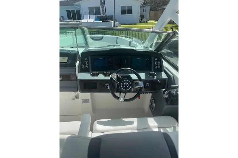 Slide: The Image of 2021 Chaparral 280 OSX boat dashboard with steering wheel and control panel. - 24