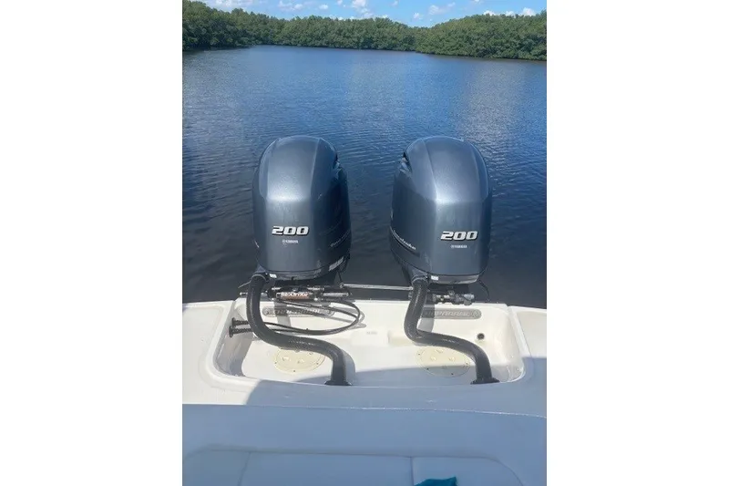 Slide: The Image of Twin Yamaha 200 engines on a 2021 Chaparral 280 OSX boat, serene lake backdrop. - 46