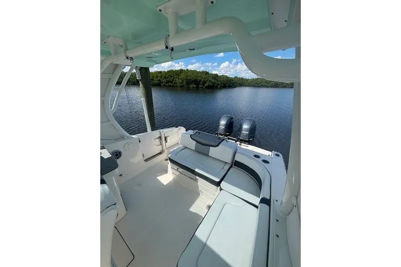 Slide: The Image of 2021 Chaparral 280 OSX boat interior with seating, overlooking serene water and lush greenery. - 40