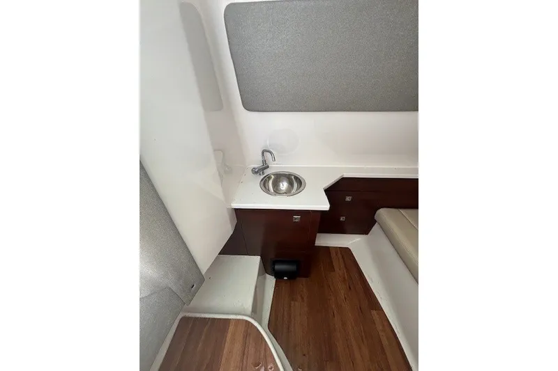 Slide: The Image of 2021 Chaparral 280 OSX cabin interior with sink and wooden flooring. - 31