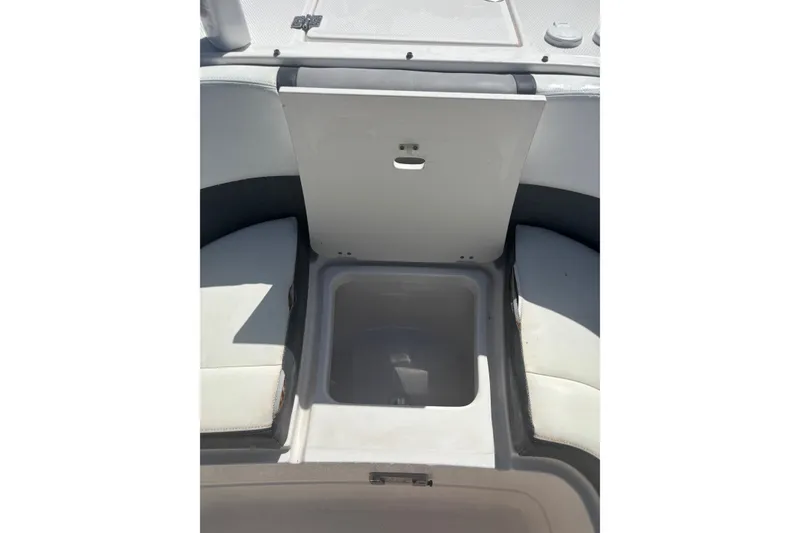 Slide: The Image of 2021 Chaparral 280 OSX boat storage compartment with open lid, showcasing interior space. - 15