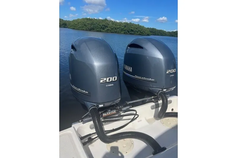 Slide: The Image of Twin Yamaha 200 outboard engines on a 2021 Chaparral 280 OSX boat, on a serene lake. - 47