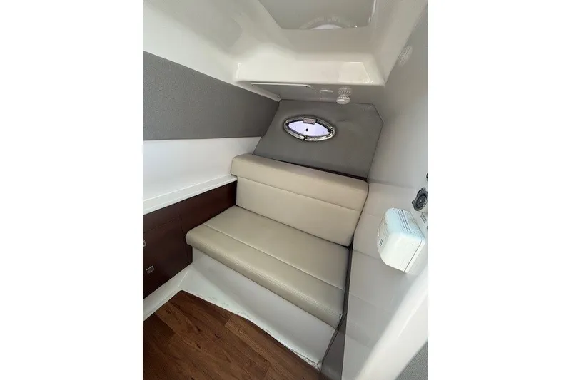 Slide: The Image of Interior cabin of 2021 Chaparral 280 OSX boat with beige seating and porthole window. - 32