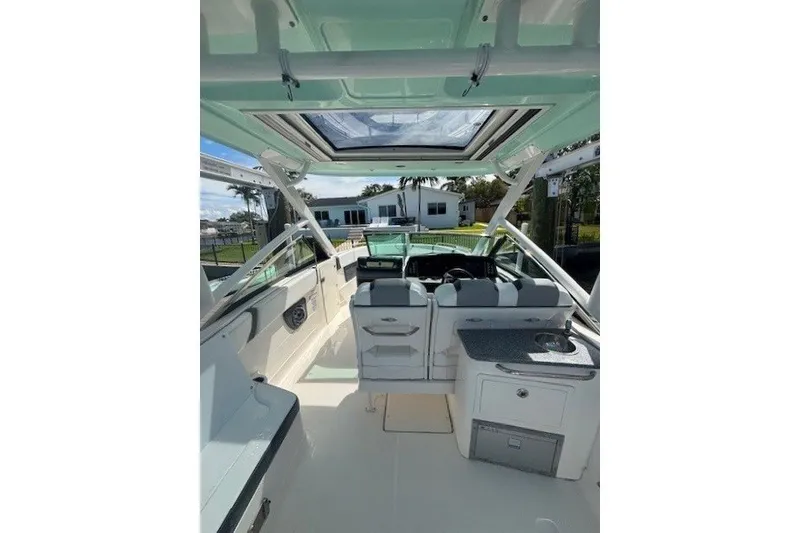 Slide: The Image of 2021 Chaparral 280 OSX boat interior with seating, helm, and kitchenette. - 35