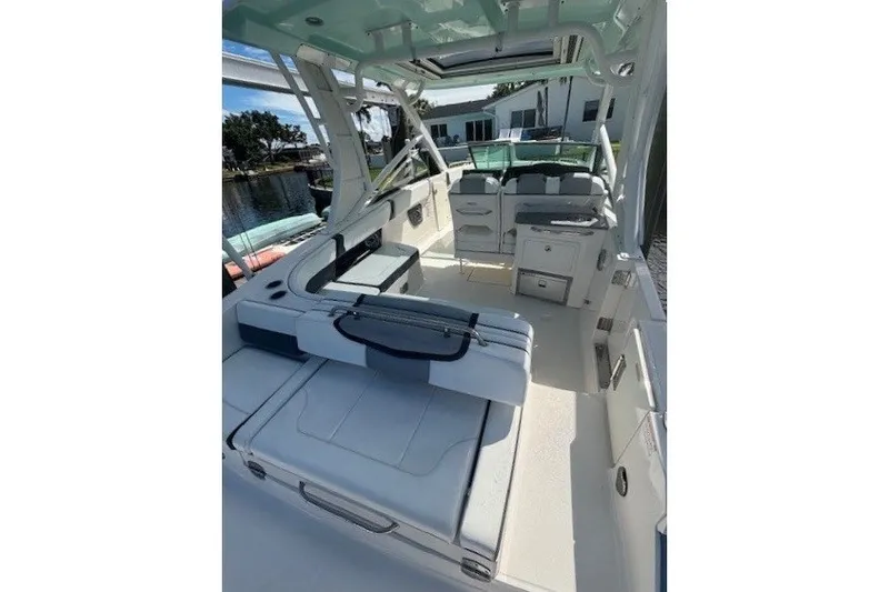 Slide: The Image of 2021 Chaparral 280 OSX boat interior with seating and helm, docked by waterfront. - 41