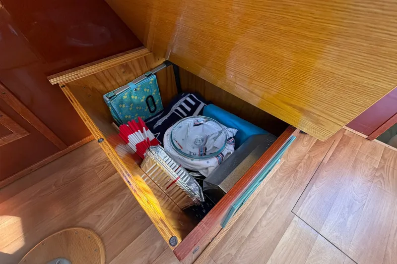 Slide: The Image of Storage compartment in 1973 Chris-Craft 31 Sedan Cruiser with various items and wooden flooring. - 30