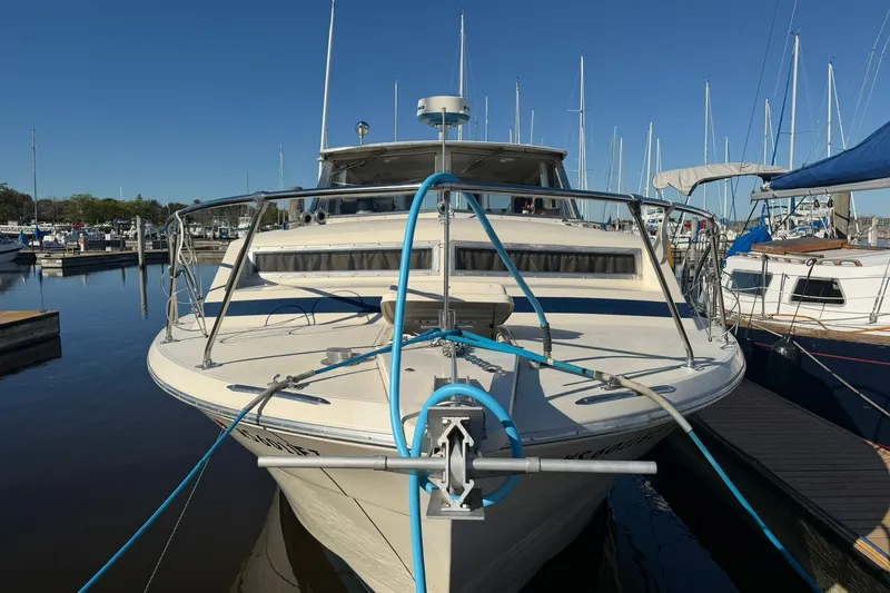 Slide: The Image of 1973 Chris-Craft 31 Sedan Cruiser docked at a marina under clear blue skies. - 3