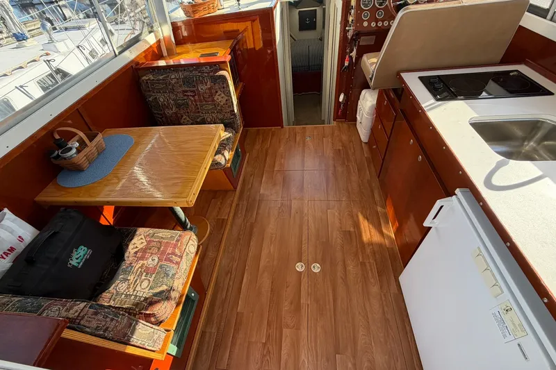 Slide: The Image of Interior of a 1973 Chris-Craft 31 Sedan Cruiser with wood flooring and compact kitchen. - 28