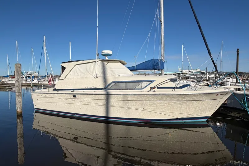 Slide: The Image of 1973 Chris-Craft 31 Sedan Cruiser docked in a marina under clear blue skies. - 5