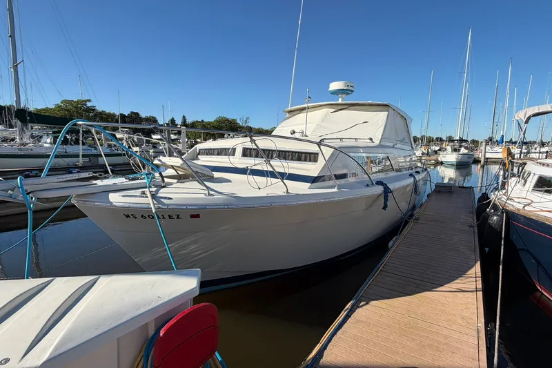 Slide: The Image of 1973 Chris-Craft 31 Sedan Cruiser docked at a marina under clear blue skies. - 9