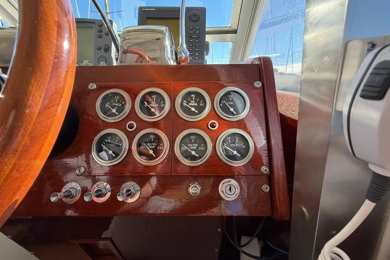 Slide: The Image of 1973 Chris-Craft 31 Sedan Cruiser dashboard with gauges and controls, featuring a wooden steering wheel. - 37