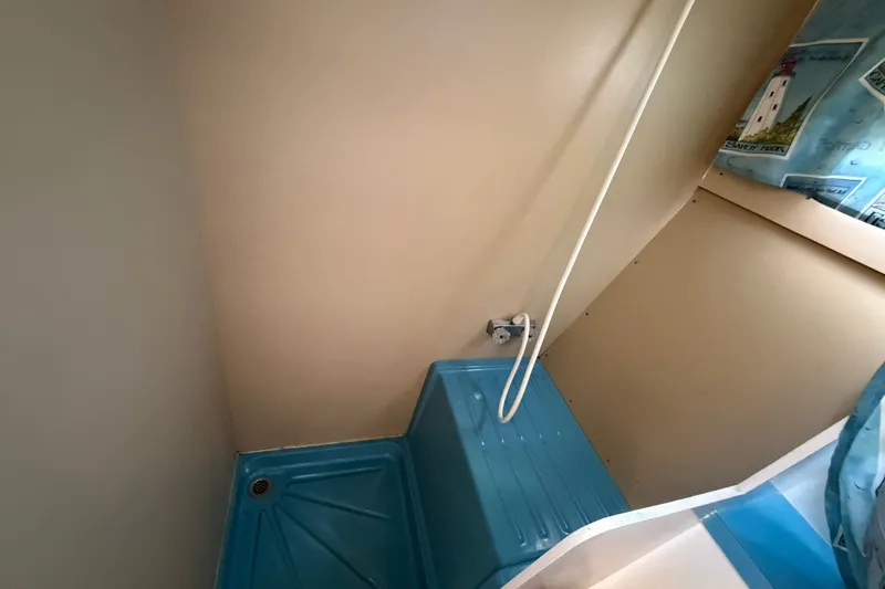 Slide: The Image of 1973 Chris-Craft 31 Sedan Cruiser shower area with blue base and beige walls. - 50
