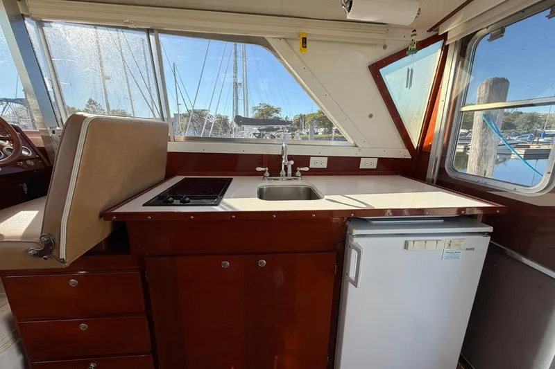 Slide: The Image of Interior of a 1973 Chris-Craft 31 Sedan Cruiser featuring a compact kitchen area. - 34