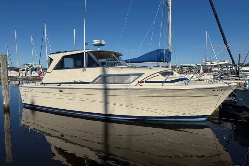 Slide: The Image of 1973 Chris-Craft 31 Sedan Cruiser docked in a marina under clear blue skies. - 1