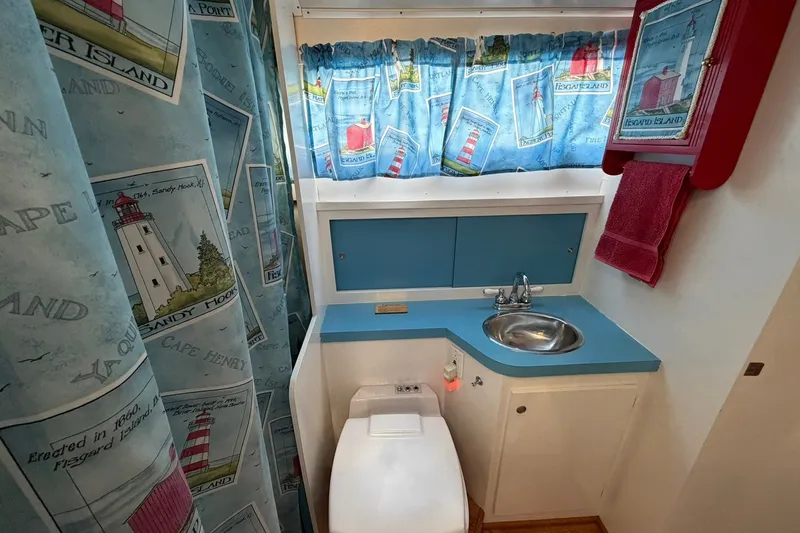 Slide: The Image of 1973 Chris-Craft 31 Sedan Cruiser bathroom with nautical-themed decor and compact sink. - 48