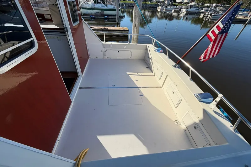 Slide: The Image of 1973 Chris-Craft 31 Sedan Cruiser deck with American flag, docked at marina. - 11
